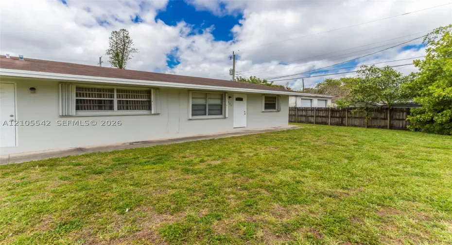 Expansive yard with mature landscaping and a wood fence