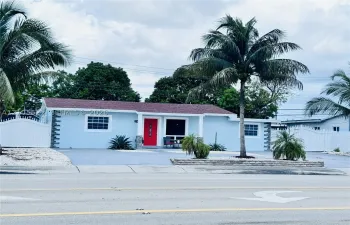 Light blue exterior with white trim windows and a red entry door