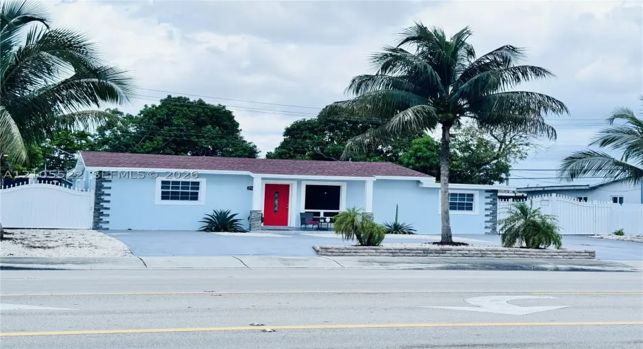 Light blue exterior with white trim windows and a red entry door