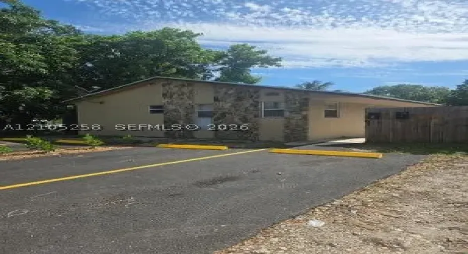 Asphalt parking area with yellow striping and parking blocks