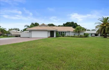 Single-story residence with a light-colored tile roof, attached two-car garage, and a wide driveway