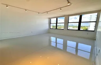 Track lighting fixtures, expansive windows, city horizon, and reflective tile flooring