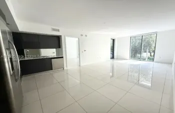 Large-format tile flooring, flat-panel dark cabinetry, stainless steel appliances, and floor-to-ceiling glass sliding doors