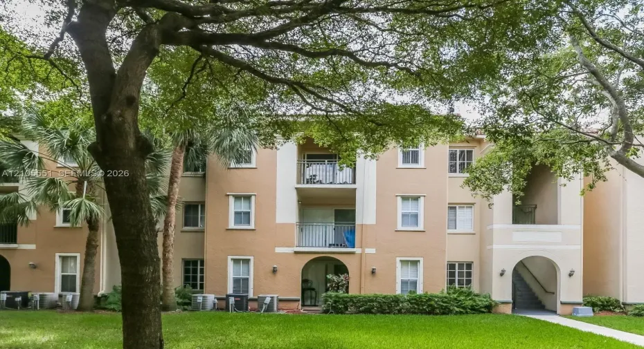 Multi-story building with stucco exterior and private balconies