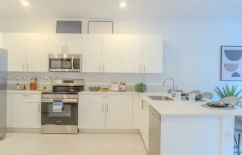 Kitchen featuring flat-panel white cabinetry, stainless steel appliances, solid-surface countertops, recessed lighting, and tile flooring