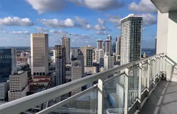Expansive city skyline, glass and metal balcony railing, and concrete flooring