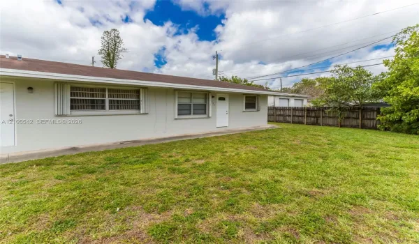 Expansive yard with mature landscaping and a wood fence