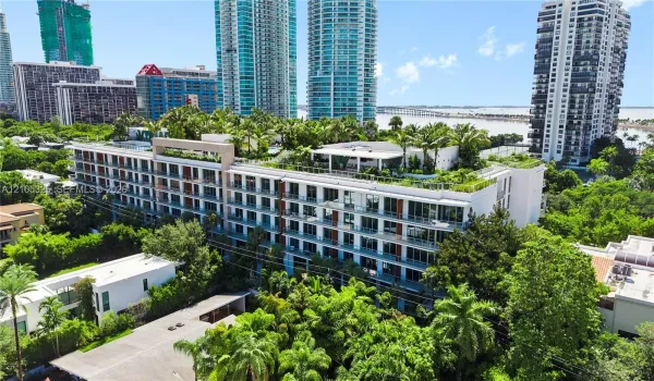 Modern multi-story building featuring extensive rooftop landscaping and multiple balconies