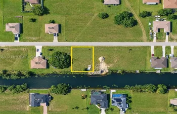 Vacant lot featuring direct canal access, established grass coverage, and rectangular parcel dimensions