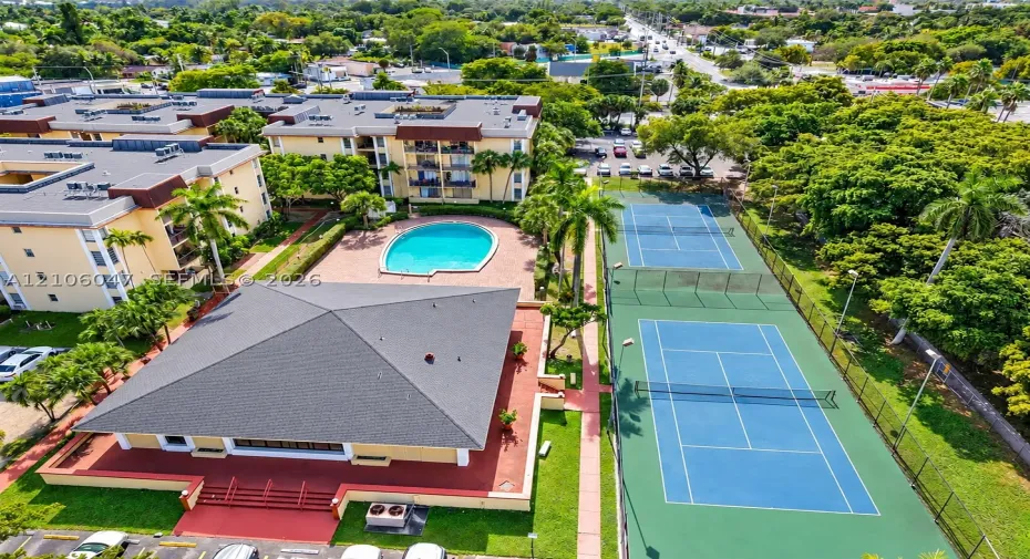 Community amenities featuring two fenced tennis courts, a swimming pool, and landscaped green space