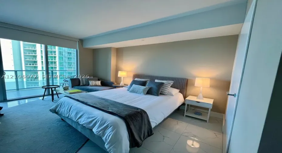 Floor-to-ceiling glass sliding doors, stone-finish tile flooring, and integrated ceiling lighting