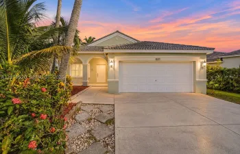 Single-story residence featuring a concrete tile roof, arched entryway, attached two-car garage, and stone paver accents