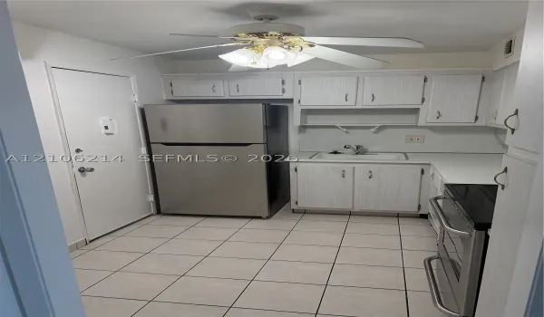 Kitchen featuring light-finish cabinetry, stainless steel refrigerator, integrated range, ceramic tile flooring, and a ceiling fan with integrated lighting