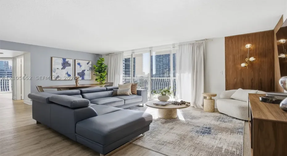 Open-concept living space featuring wood-finish flooring, floor-to-ceiling glass sliding doors, and a wood-paneled accent wall with integrated multi-globe lighting