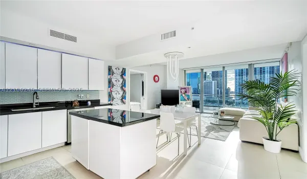 Kitchen featuring flat-panel white cabinetry, black stone countertops, tile backsplash, a matching center island, and floor-to-ceiling glass windows