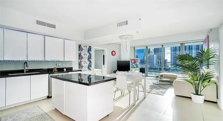 Kitchen featuring flat-panel white cabinetry, black stone countertops, tile backsplash, a matching center island, and floor-to-ceiling glass windows