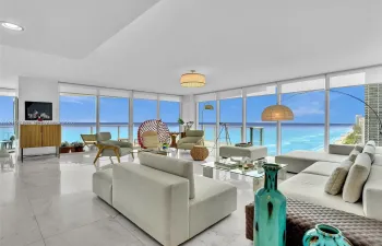 Elegant living area featuring Carrara marble flooring, floor-to-ceiling windows, stunning ocean views, and recessed ceiling lighting.