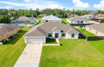 Single-story residence featuring a hipped roof, attached two-car garage, concrete driveway, and front lawn