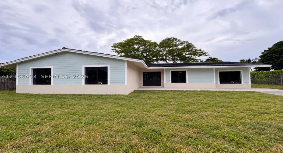 Single-story residence featuring light-toned horizontal siding, a stucco exterior finish, dark-frame windows, and a concrete driveway