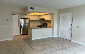 Kitchen featuring white cabinetry, stone-finish countertops, stainless steel refrigerator, and tiled flooring