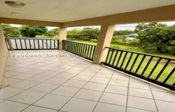 Covered balcony featuring square tile flooring and black metal railing