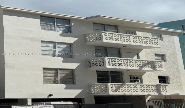 Multi-level exterior facade featuring a smooth stucco finish, grid-patterned privacy screens on each balcony, and horizontal sliding windows