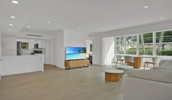 Open-concept interior featuring light wood-finish flooring, recessed lighting, and large windows with horizontal muntins