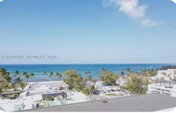 Elevated perspective overlooking the coastline, featuring expansive ocean scenery, mature tropical vegetation, and surrounding coastal structures