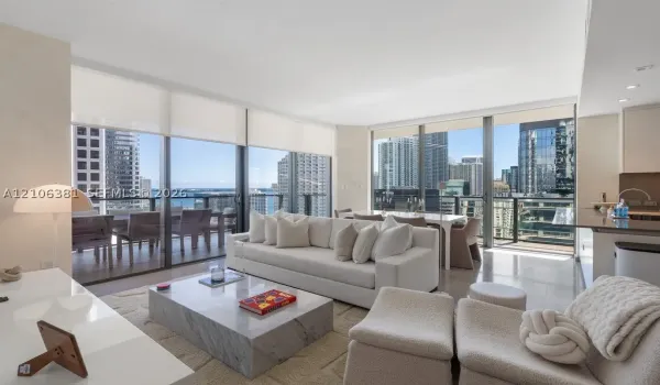 Living area featuring floor-to-ceiling glass windows, recessed lighting, polished stone flooring, and a private balcony