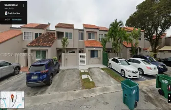 Two-story exterior featuring a clay tile roof, stucco facade, private gated courtyard entry, and dedicated concrete parking pads