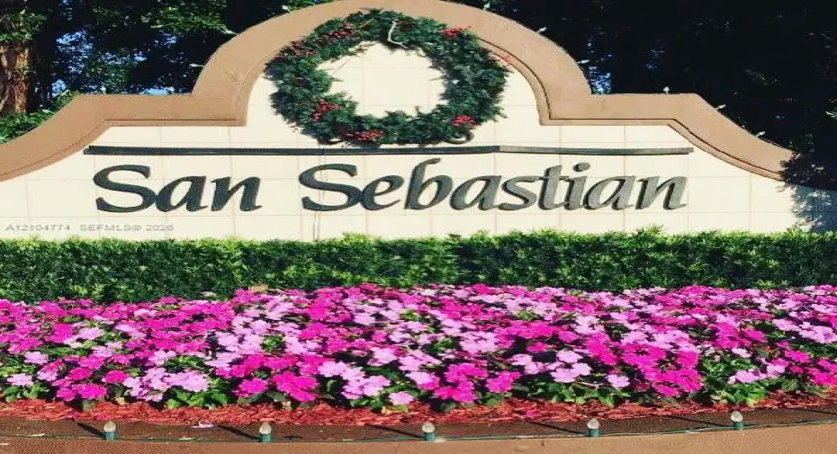 Custom stone-finish community monument sign featuring dimensional lettering and tiered landscaping with flowering ground cover and manicured hedges