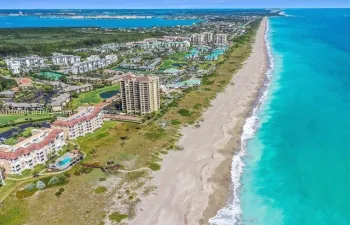Coastal community with beachfront access, multiple residential buildings, and a swimming pool