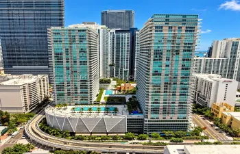 High-rise residential towers featuring floor-to-ceiling glass facades, multiple outdoor swimming pools, landscaped terrace areas, and structural parking podiums