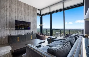 Floor-to-ceiling windows, textured accent wall, and glass-paneled balcony railing