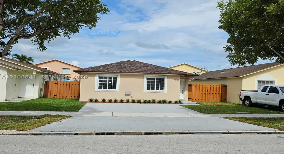 Single-story residence featuring a hipped roof, concrete driveway, and front-facing windows with muntin detailing