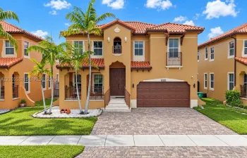 Mediterranean-style exterior with a terra cotta tile roof, stucco finish, and an integrated two-car garage