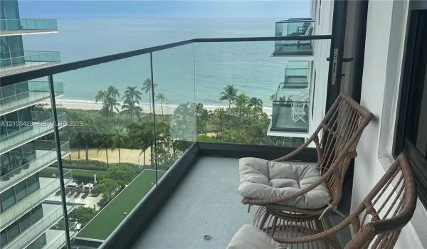 Expansive balcony with glass panel railing and ocean scenery