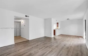 Open-concept interior featuring wood-finish flooring, neutral walls, recessed light fixture, and built-in closet with louvered doors