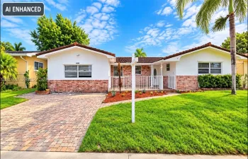 Single-story exterior featuring a brick and stucco facade, decorative tile roof, paved driveway, and white metal front railing