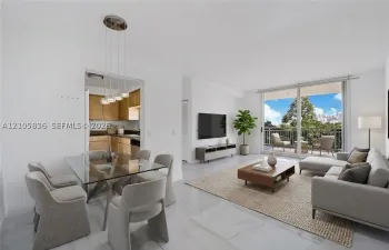 Open-concept living area featuring light-toned flooring, sliding glass doors to a private balcony, and a multi-light pendant fixture above the dining area
