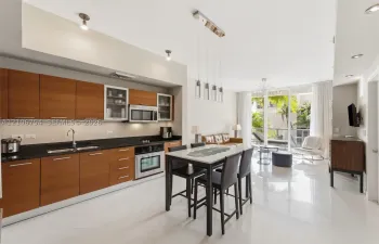 Modern kitchen featuring wood-finish cabinetry, dark solid-surface countertops, built-in stainless steel appliances