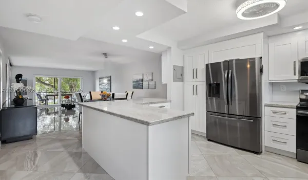 Kitchen featuring white cabinetry, stone countertops, stainless steel appliances, tile flooring, and recessed ceiling lighting