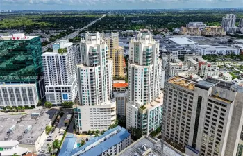 Aerial perspective of dual-tower high-rise residential architecture featuring glass-paneled balconies and a central podium structure