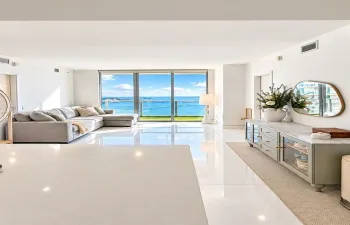 Open-concept living space featuring expansive floor-to-ceiling glass doors, high-gloss tile flooring, and direct exterior water access