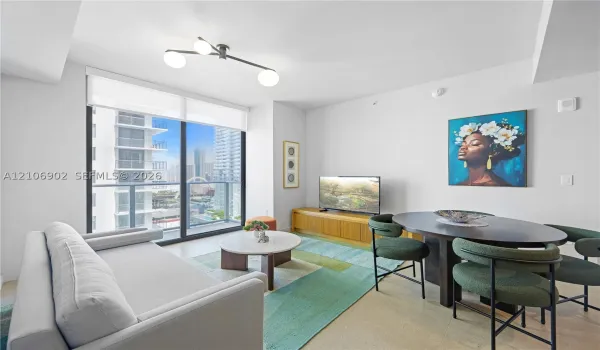 Floor-to-ceiling windows, matte black multi-arm light fixture, and light-toned flooring