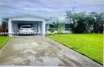 Single-story residence featuring a covered carport, concrete driveway, and established landscaping with mature palm trees