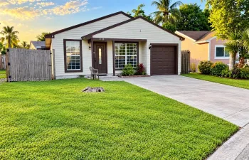 Single-story residence featuring horizontal siding, a covered entryway, a concrete driveway, an attached garage, and a wood-slat privacy fence