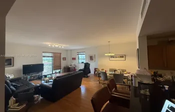 Open-concept interior featuring wood-finish flooring, a breakfast bar with stone-finish surfacing, and multiple windows