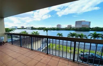 Covered terrace with terracotta-style tile flooring and a dark metal railing overlooking a waterway