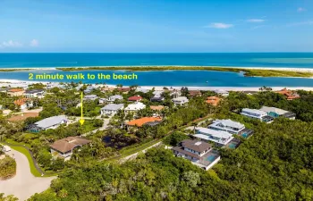 Aerial perspective featuring a coastal setting, lush surrounding vegetation, and proximity to the shoreline